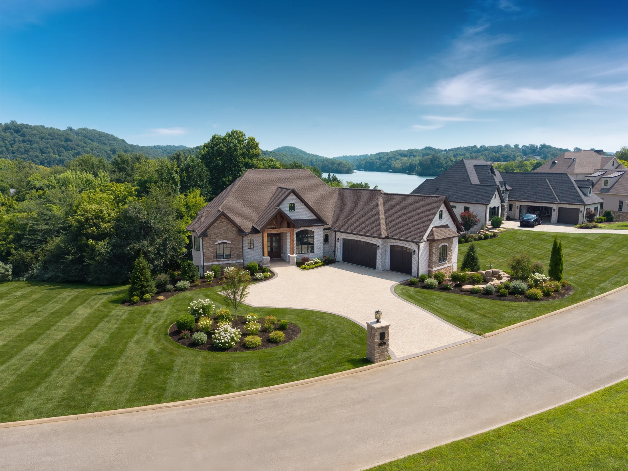 Kingsley home aerial showing the front elevation, landscaped lawn and lake beyond